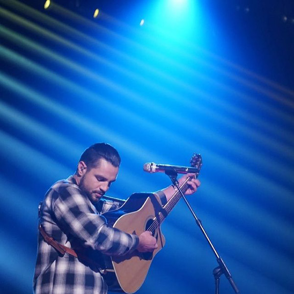 Chayce playing guitar with blue lights behind him